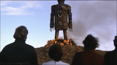 Group Standing Before Burning Statue Mulled Wine Must Die GIF
