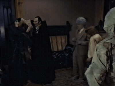 Group Standing In Dark Room One Wearing Hood GIF