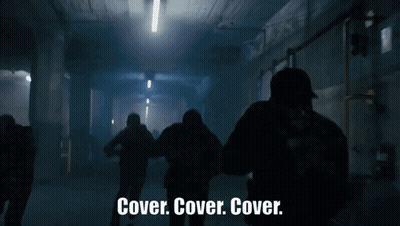 Group Standing In Dark Room Saying Cover Cover Cover GIF