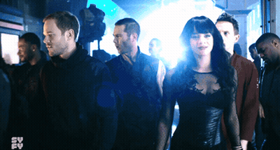 Group Standing In Dark Room With Syfy Logo GIF