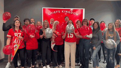 Group Standing In Front Of Chiefs Kingdom Sign GIF