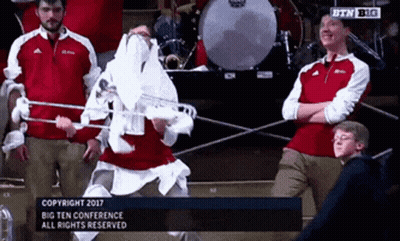 Group Standing In Front Of Drum Set And Big Ten Conference Sign GIF
