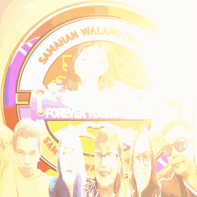 Group Standing In Front Of Forever Young Sign GIF