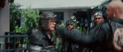 Group Standing In Front Of House With Man In Helmet GIF