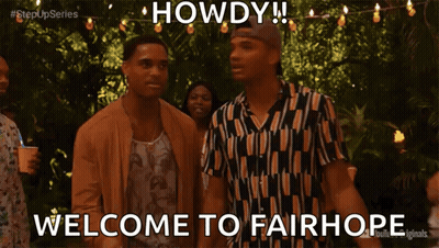 Group Standing In Front Of Howdy Sign GIF