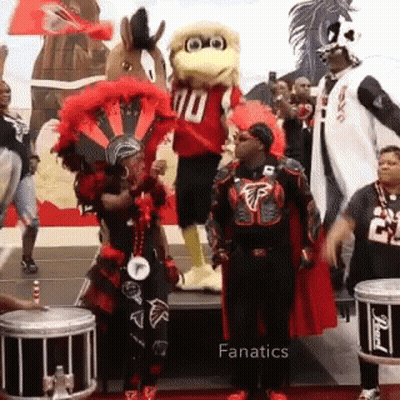 Group Standing In Front Of Mascot In Number 10 Jersey GIF