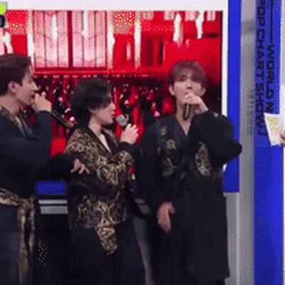 Group Standing In Front Of Pop Chart Show Sign GIF