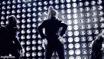 Group Standing In Front Of Wall Of Lights GIF