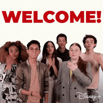 Group Standing In Front Of Welcome Sign GIF