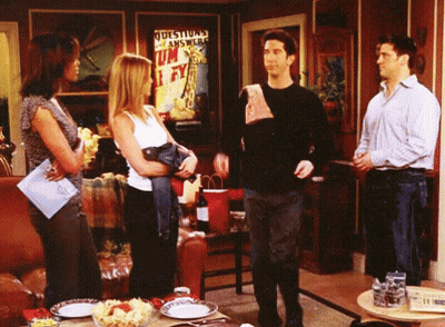 Group Standing In Living Room With Questions Answered Sign GIF