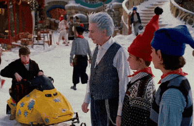Group Standing In Snow With Snowmobile GIF