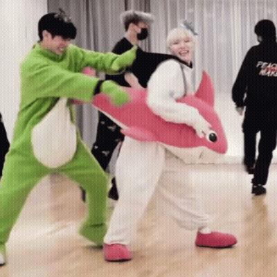 Group Standing With One In Pink Shark Costume GIF