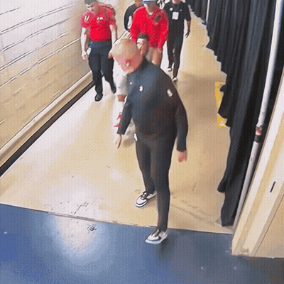 Group Walking Down Hallway With Nike Logo Jacket GIF