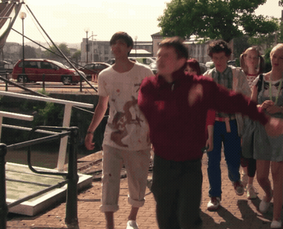 Group Walking Down Sidewalk One With Dirty Shirt GIF