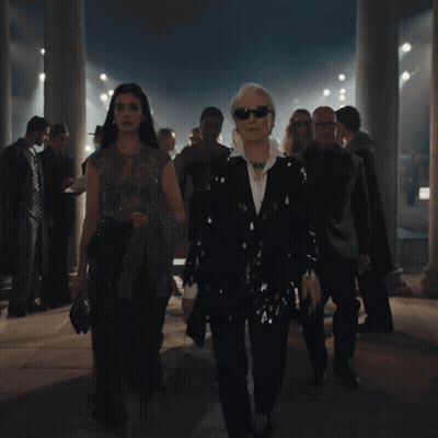 Group Walking In Dark Room With Columns GIF