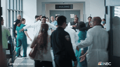 Group Walking In Hallway With Building Sign GIF