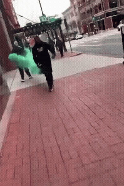 Group Walking On Brick Sidewalk With Green Dress GIF