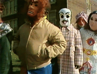 Group Wearing Masks In Front Of Gh-Zst Sign GIF