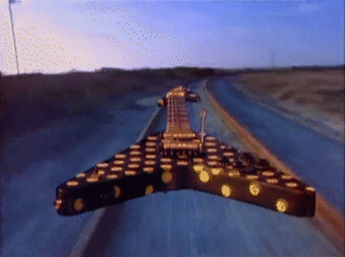 Guitar Driving Down Highway at Sunset