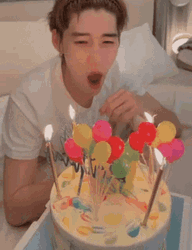 Guy Blowing Birthday Candles On Cake