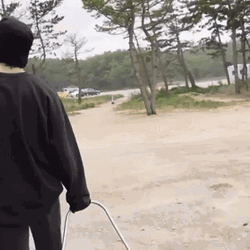 Guy Walking While Dragging A Q Drum GIF