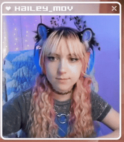 Hailey Moy Is Wearing A Cat Ear Headband And Headphones While Sitting In A Chair . GIF