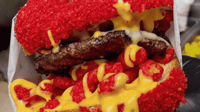 Hamburger Covered In Red And Yellow Toppings GIF