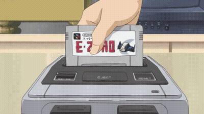 Hand Inserting Super Nintendo Cartridge Into Video Game Console GIF