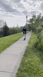 Happy Young Girl Riding Electric Scooter GIF