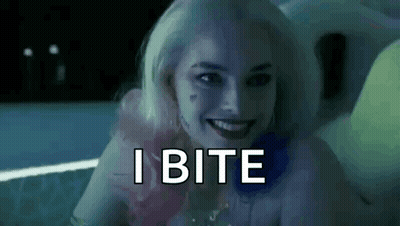 Harley Quinn From Suicide Squad Is Smiling And Says `` I Bite '' While Sitting In A Bathtub . GIF