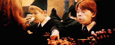 Harry Potter And Ron Weasley Are Sitting At A Table Eating Food And Drinking . GIF