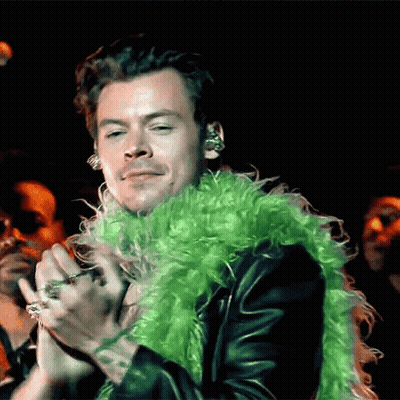 Harry Styles In Green Boa Holding Microphone GIF