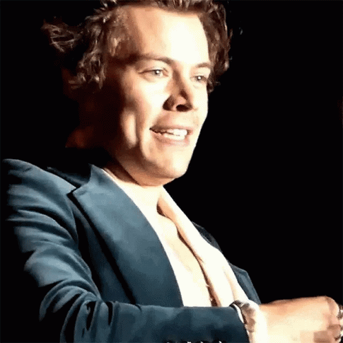 Harry Styles Is Wearing A Blue Suit And A White Shirt While Standing On A Stage . GIF