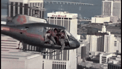 Helicopter Flying Over City With MGM Building GIF
