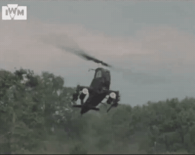 Helicopter Flying Over Forest With IWM Letters GIF
