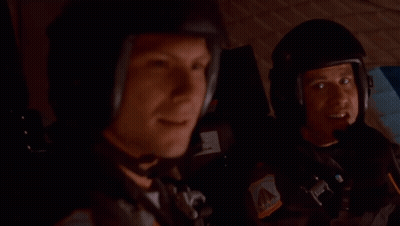 Helmeted Man Next To Man In Car GIF