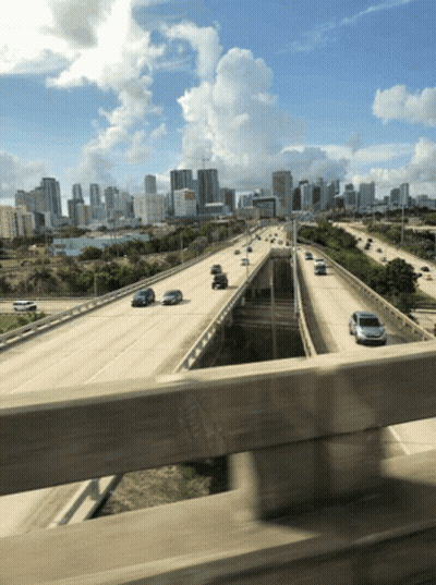 Highway With City Background And Cars Driving GIF