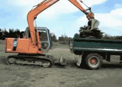 Hitachi Excavator Loading Dump Truck With Branches GIF