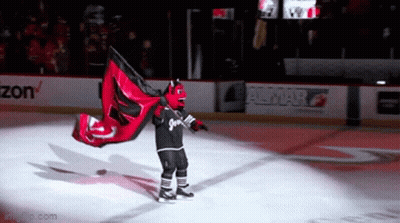 Hockey Mascot Holding Red And Black Flag With Number 2 GIF