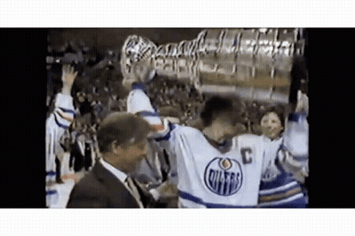 Hockey Player Holding Trophy With Man Behind GIF