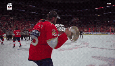 Hockey Player Holding Trophy With Mor On Jersey GIF
