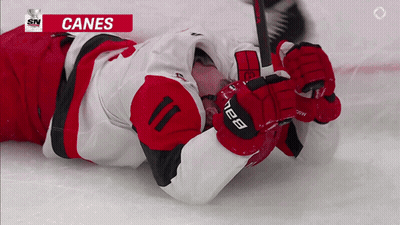 Hockey Player Laying On Ice With Canes GIF