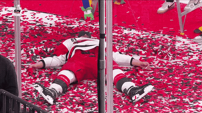 Hockey Player Laying On Red Carpet With Confetti GIF