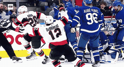Hockey Player Number 12 Surrounded By Players GIF