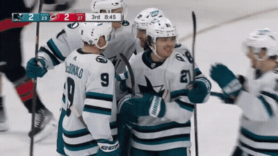 Hockey Player Number 9 Surrounded By Teammates GIF