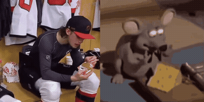 Hockey Player Sitting In Locker Room Beside Mouse Eating Cheese GIF