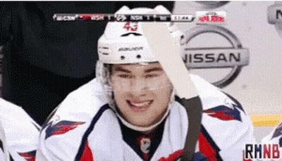 Hockey Player Smiling Near Nissan Advertisement GIF