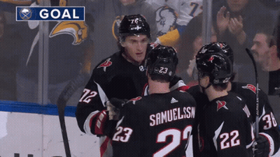 Hockey Players Celebrating Under Goal Banner GIF