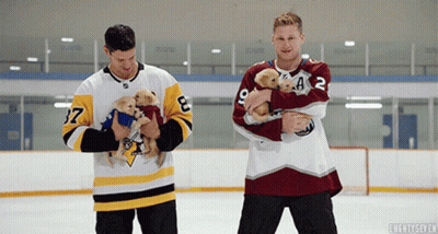 Hockey Players Holding Puppies GIF