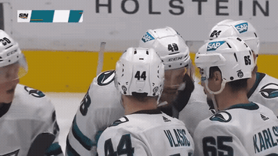 Hockey Players Huddled In Front Of Holstein Sign GIF